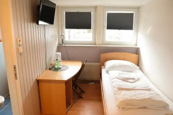 Einzelzimmer mit TV, Schreibtisch und Einzelbett